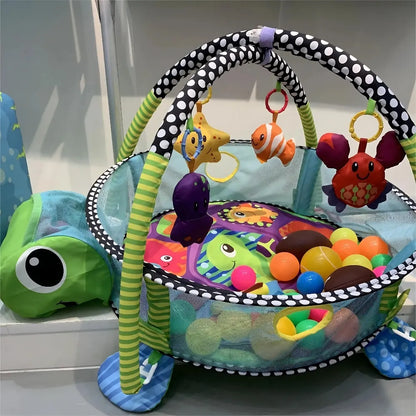 Tapis d'éveil sensoriel en forme de tortue avec jouets suspendus et boules colorées pour bébé.